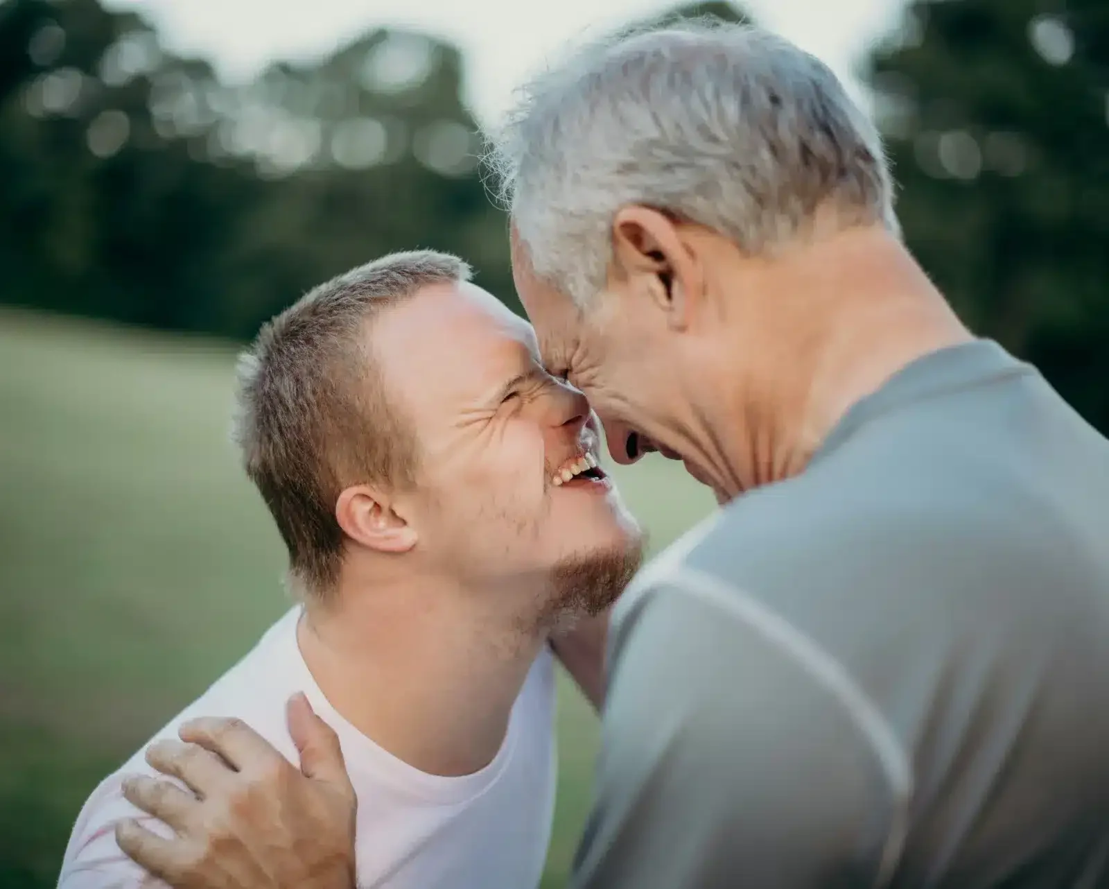 the-family-foundation Father and son with Down syndrome sharing a joyful moment outdoors representing family foundation and unconditional love